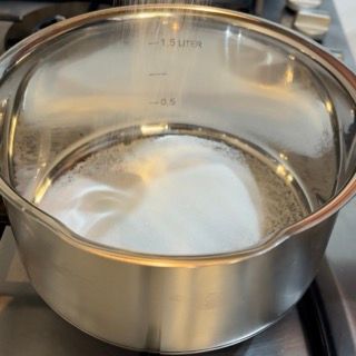 Una pentola in acciaio inossidabile con un coperchio di vetro su un fornello