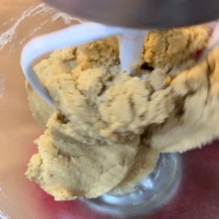 Una persona sta impastando l'impasto in un'impastatrice.