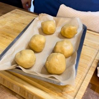 Un vassoio di patate appoggiato su un tagliere di legno