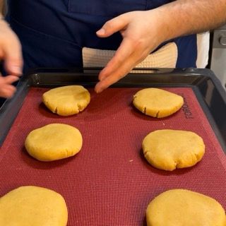 Una persona sta mettendo dei biscotti su un vassoio con la scritta toro