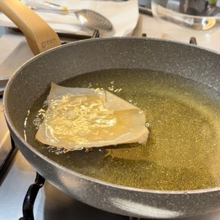 Immersione della zeppola di san giuseppe fritte in olio bollente a 170°C con la carta forno.