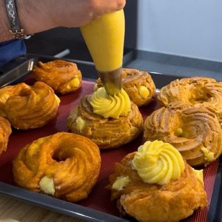 Spirale decorativa di crema pasticcera sulla superficie della zeppola di san giuseppe.