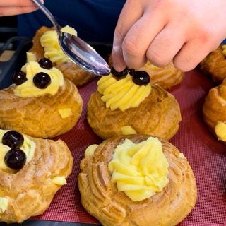 Aggiunta dell'amarena sciroppata al centro della zeppola di san giuseppe napoletana