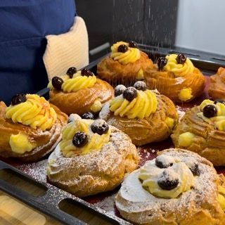 Spolverata finale di zucchero a velo sulla zeppola di san giuseppe grande pronta.