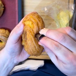 Riempimento del cuore del bignè fritto per una zeppola di san giuseppe ricetta gourmet.