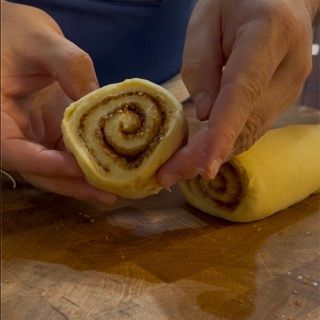 Cinnamon rolls crudi disposti in una teglia, ben distanziati