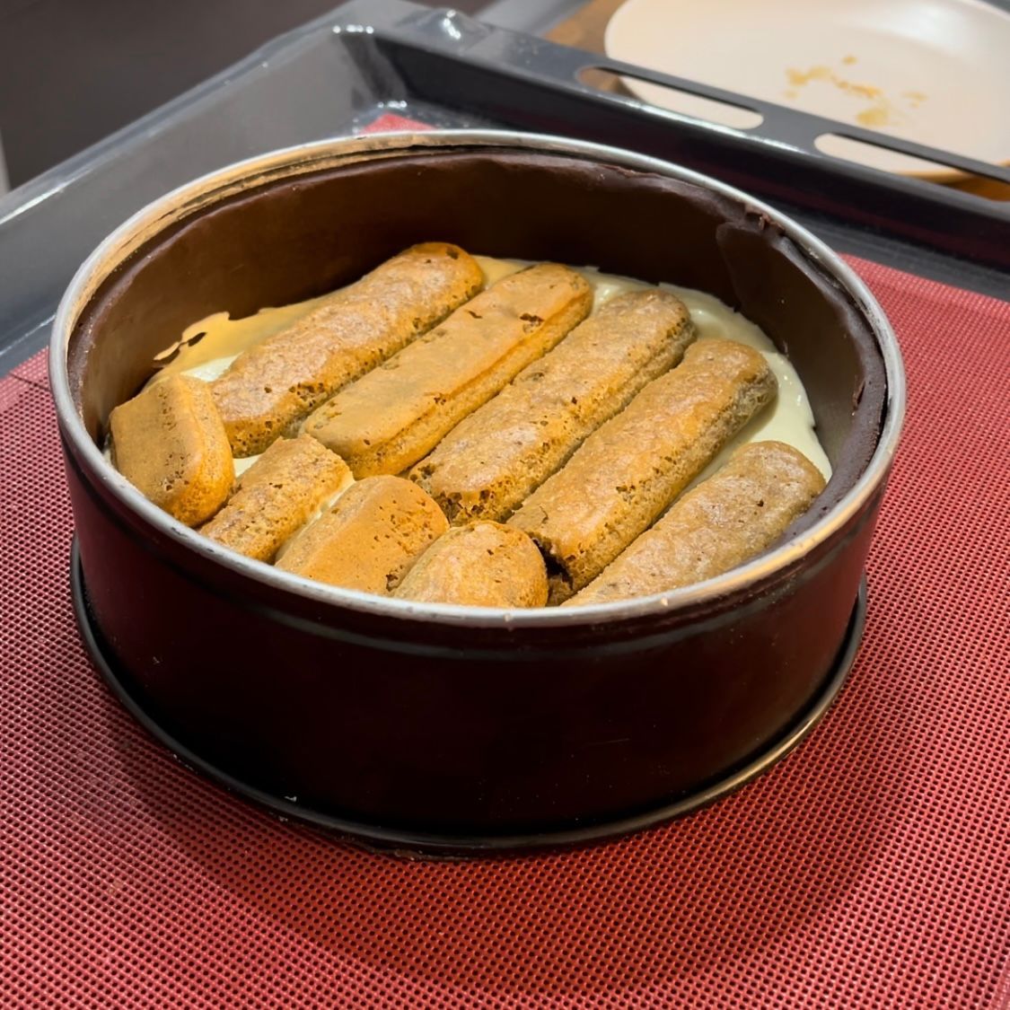 Una tortiera piena di biscotti tiramisù e crema