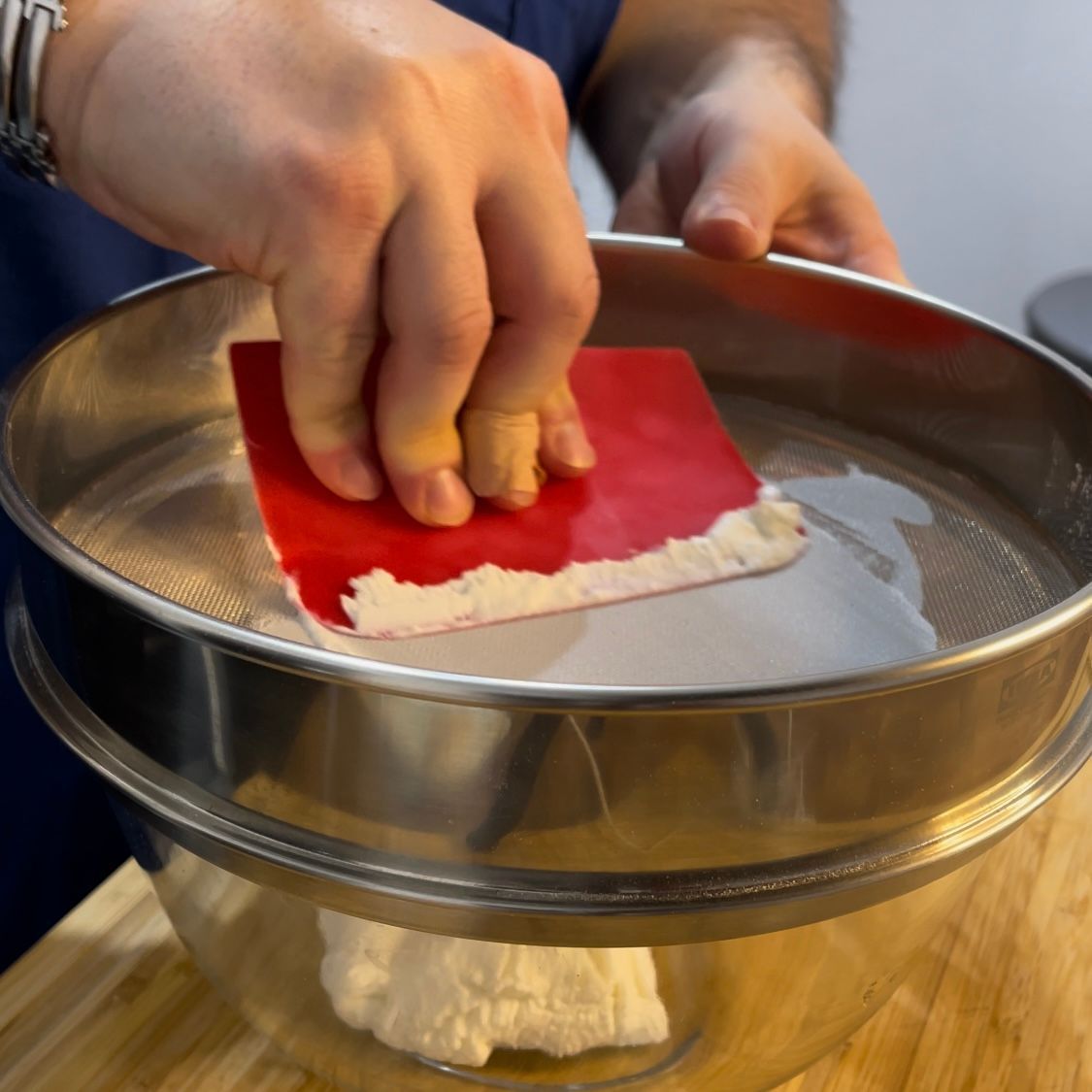 Setacciatura della ricotta di pecora per un ripieno cremoso e senza grumi.