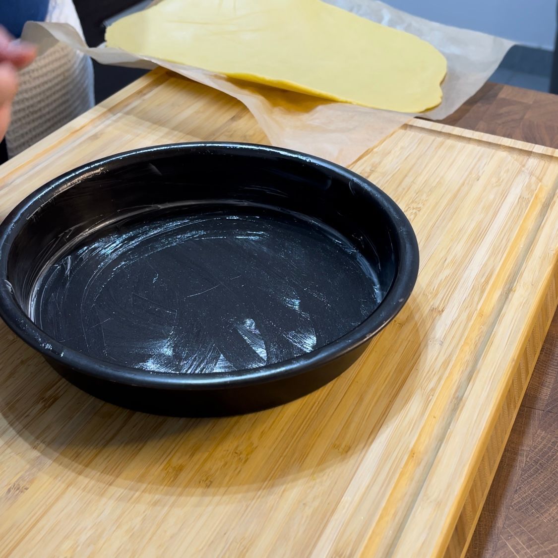 Posizionamento della pasta frolla nella teglia imburrata aiutandosi con la carta forno.