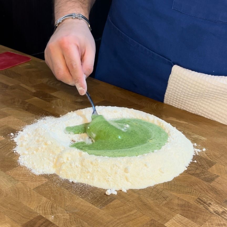 Forchetta che inizia ad amalgamare gli ingredienti per la pasta verde.