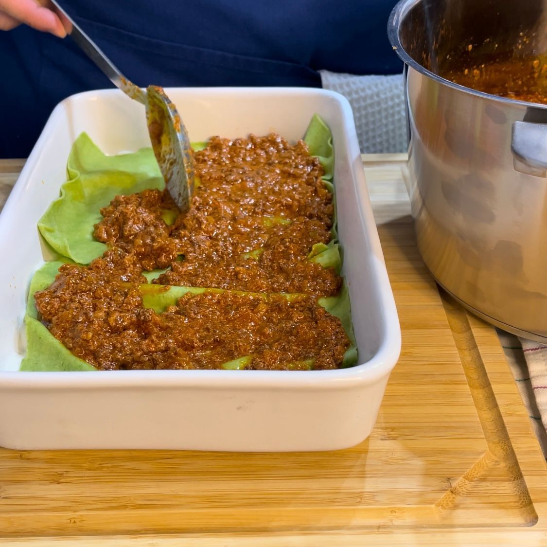 Strato uniforme di ragù alla bolognese sulla pasta.
