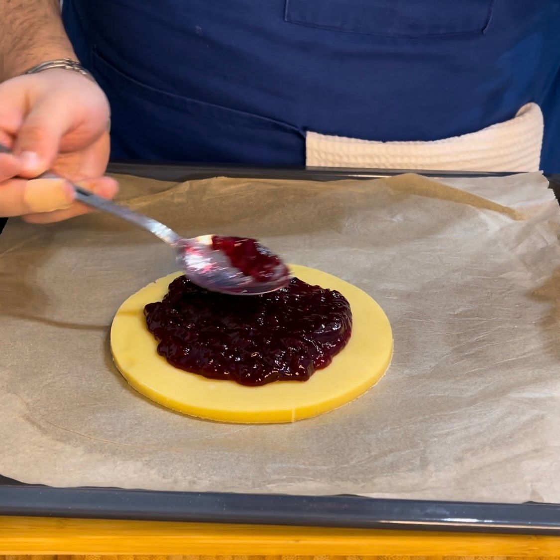 viene spalmata  la confettura di visciole  su un disco di pasta frolla 