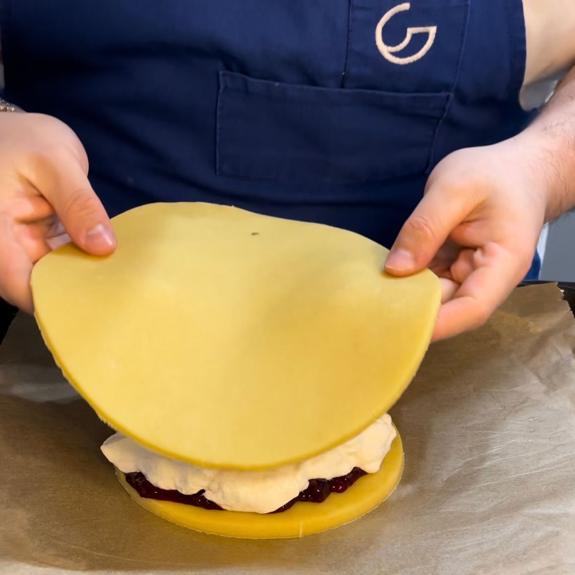 un disco di pasta frolla viene usato per coprire una crostata 