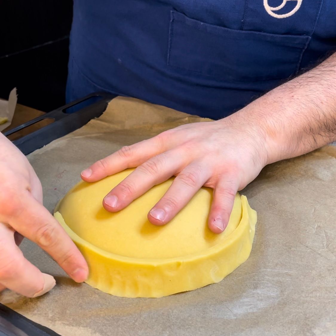una persona chiude una crostata ricotta e visciole 