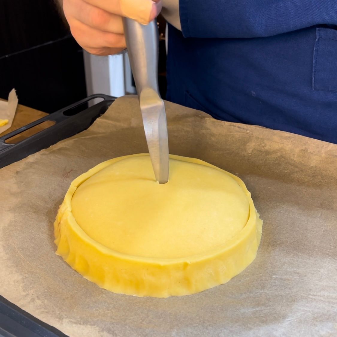 una persona chiude una crostata ricotta e visciole 