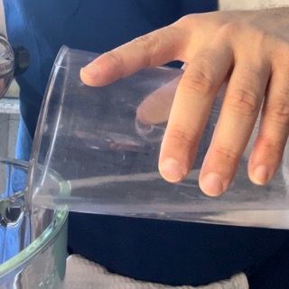 Una persona sta versando del liquido in un bicchiere