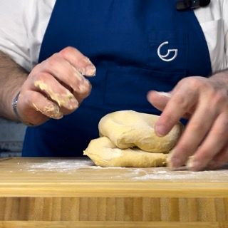 Una persona che indossa un grembiule blu con la lettera g sopra