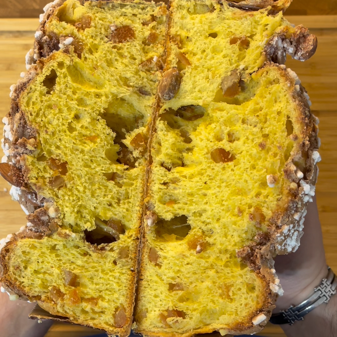 Una persona tiene in mano una pagnotta tagliata a metà.