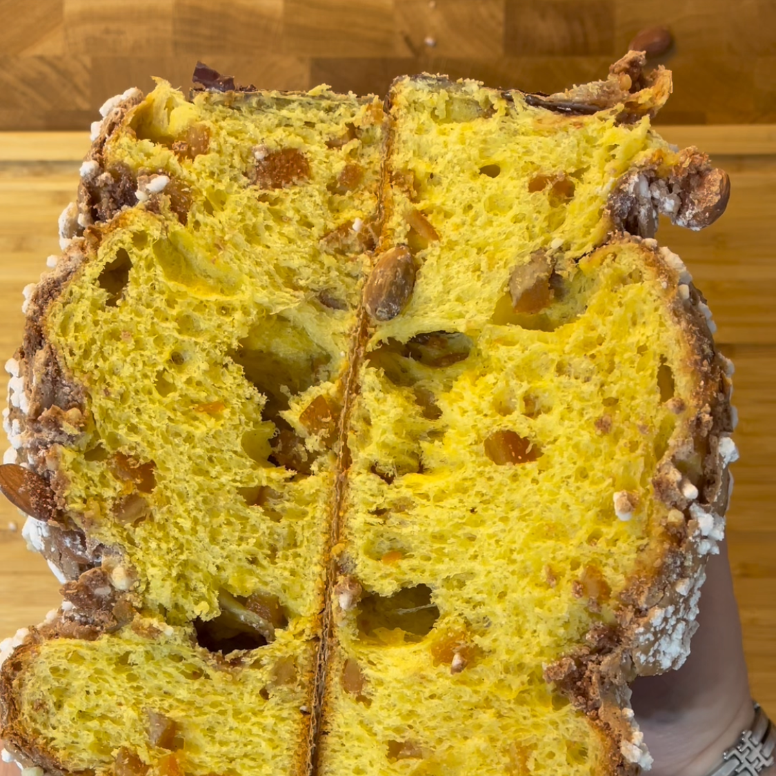 Una persona tiene in mano una pagnotta tagliata a metà.
