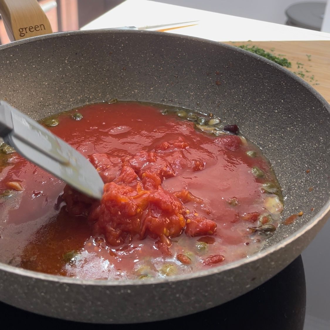 Una pentola di salsa di pomodoro viene mescolata con una spatola