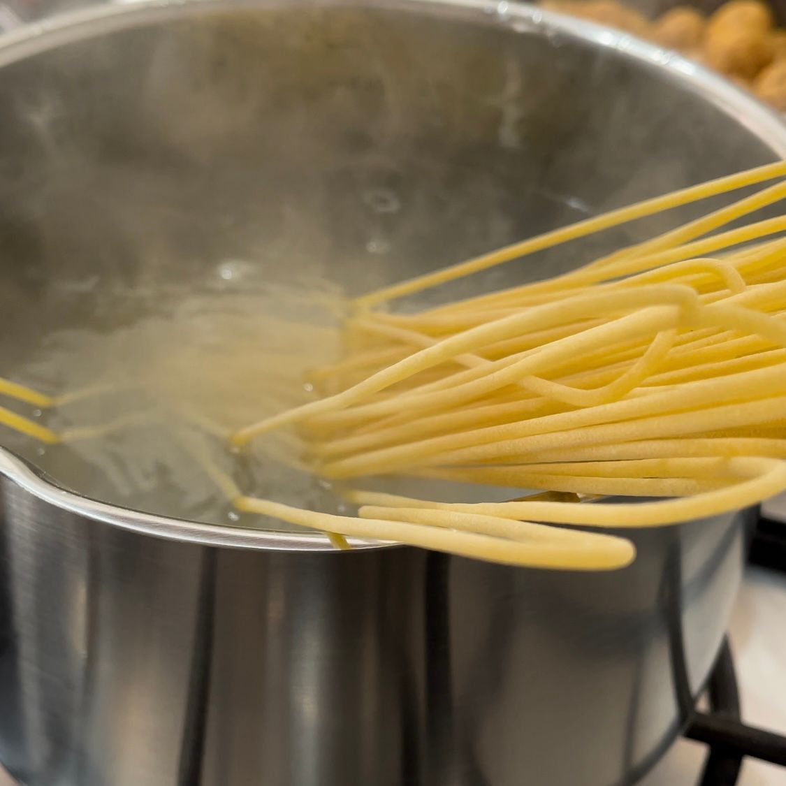 Gli spaghetti vengono versati in una pentola di acqua bollente