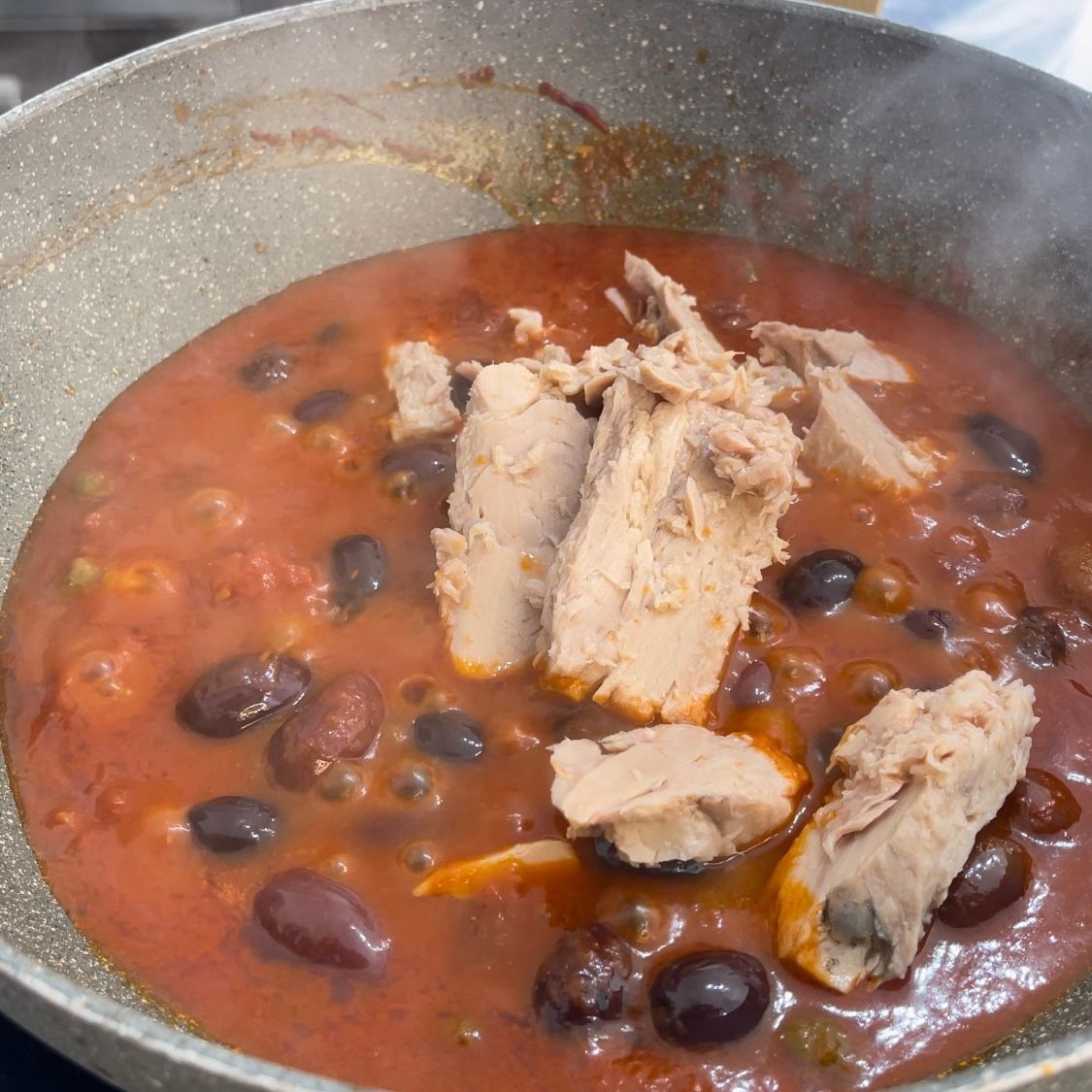 Un primo piano di una pentola di stufato con carne e fagioli