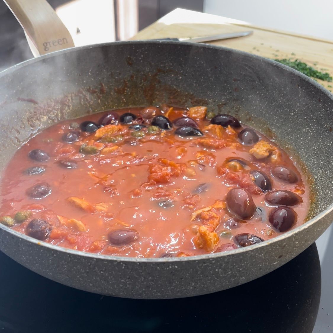 Una padella piena di salsa di pomodoro e olive