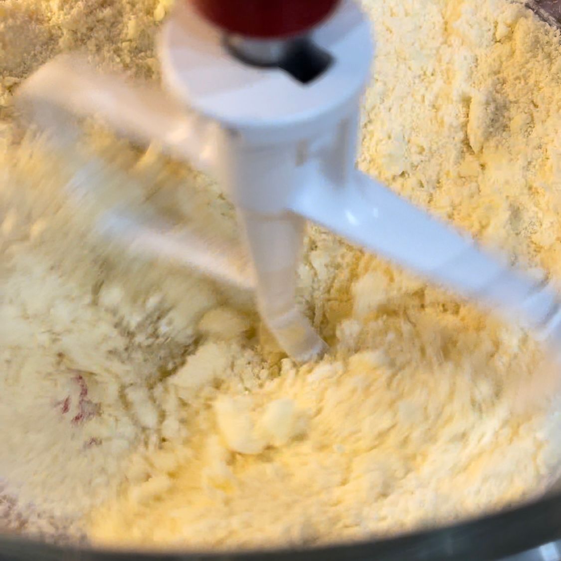 la farina in una ciotola viene lavorata con il burro per la pasta frolla 