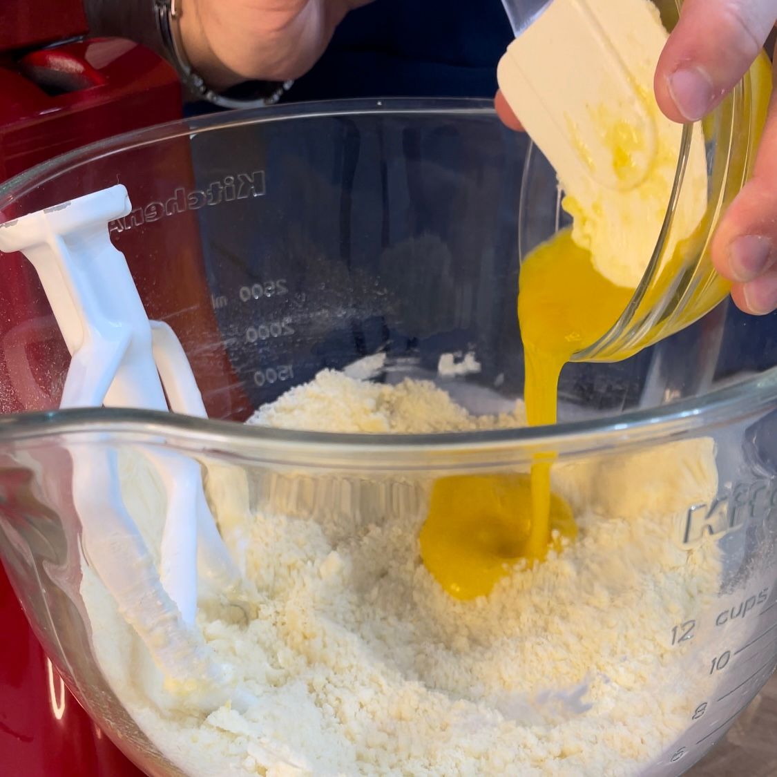 Inserimento dei tuorli nell'impasto sabbiato per legare la pasta frolla.