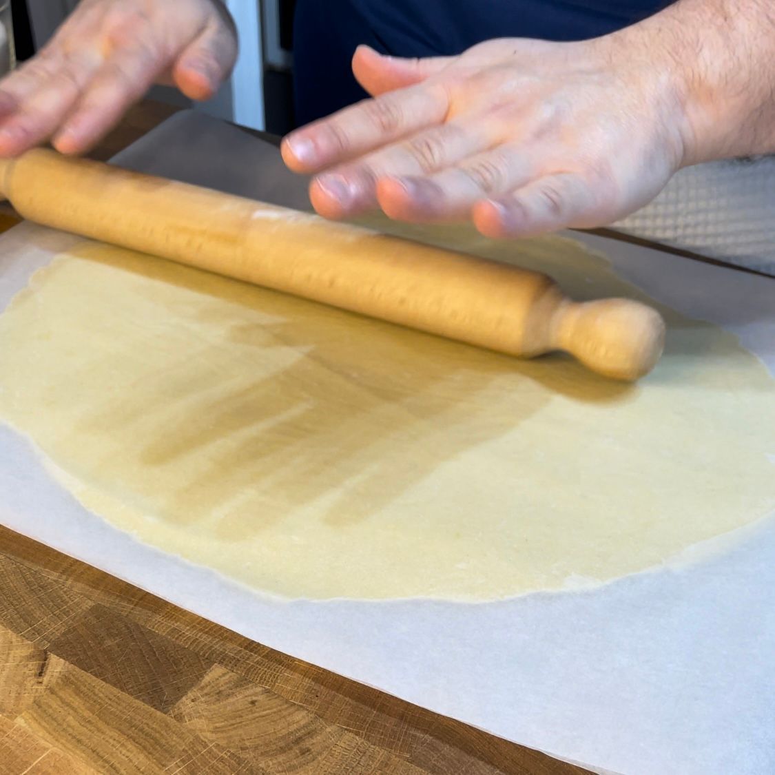 la pasta frolla viene lavorata e stesa tra due fogli di carta forno 