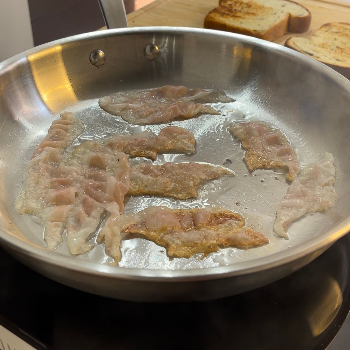 La pancetta viene cotta in una padella sul fornello