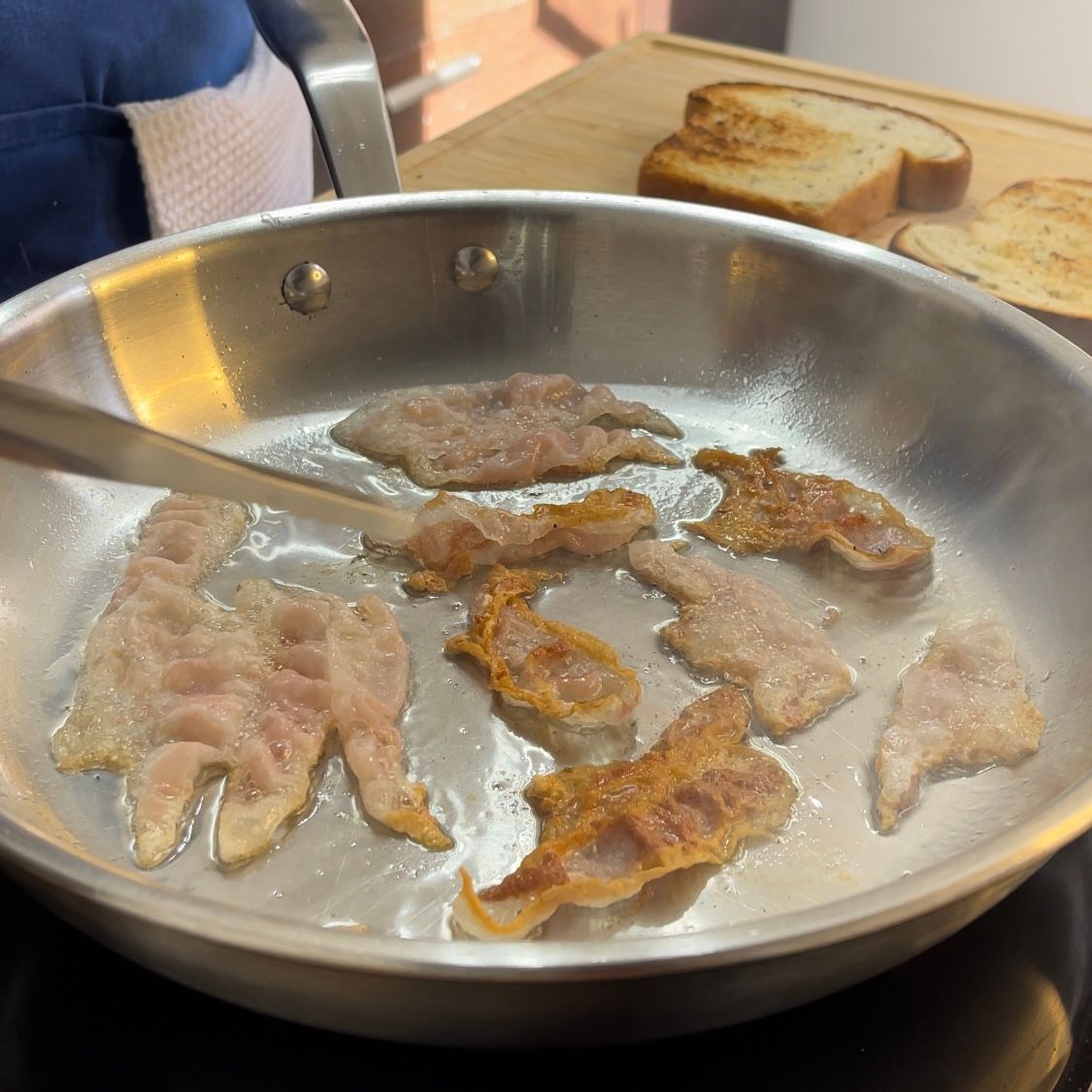 Fette di pancetta vengono cotte in una padella