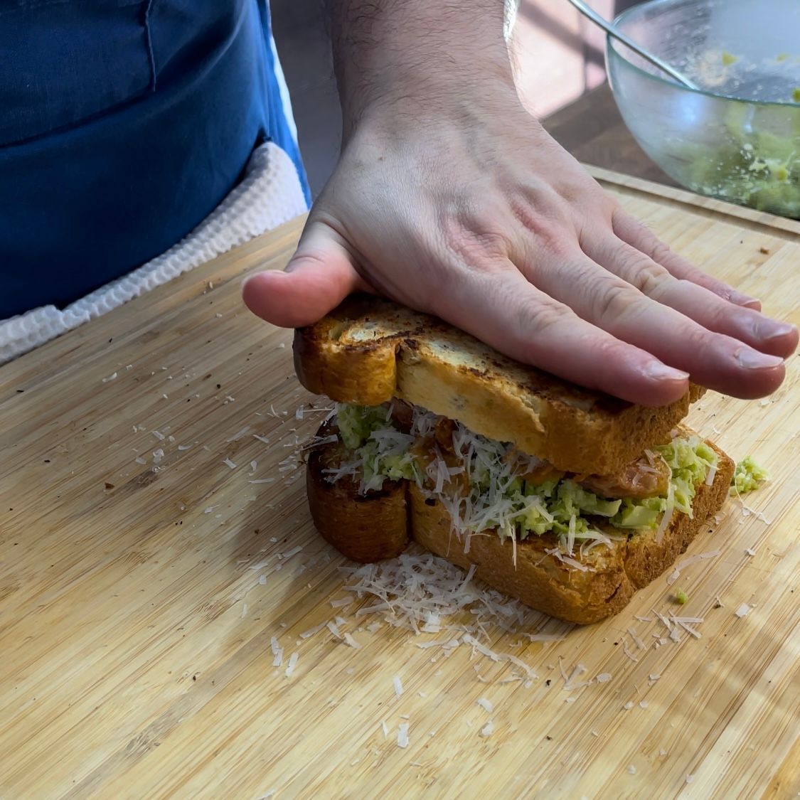 Una persona sta preparando un panino su un tagliere di legno