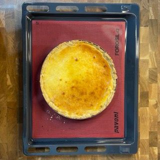 Una torta è appoggiata su una teglia con scritto pavoni
