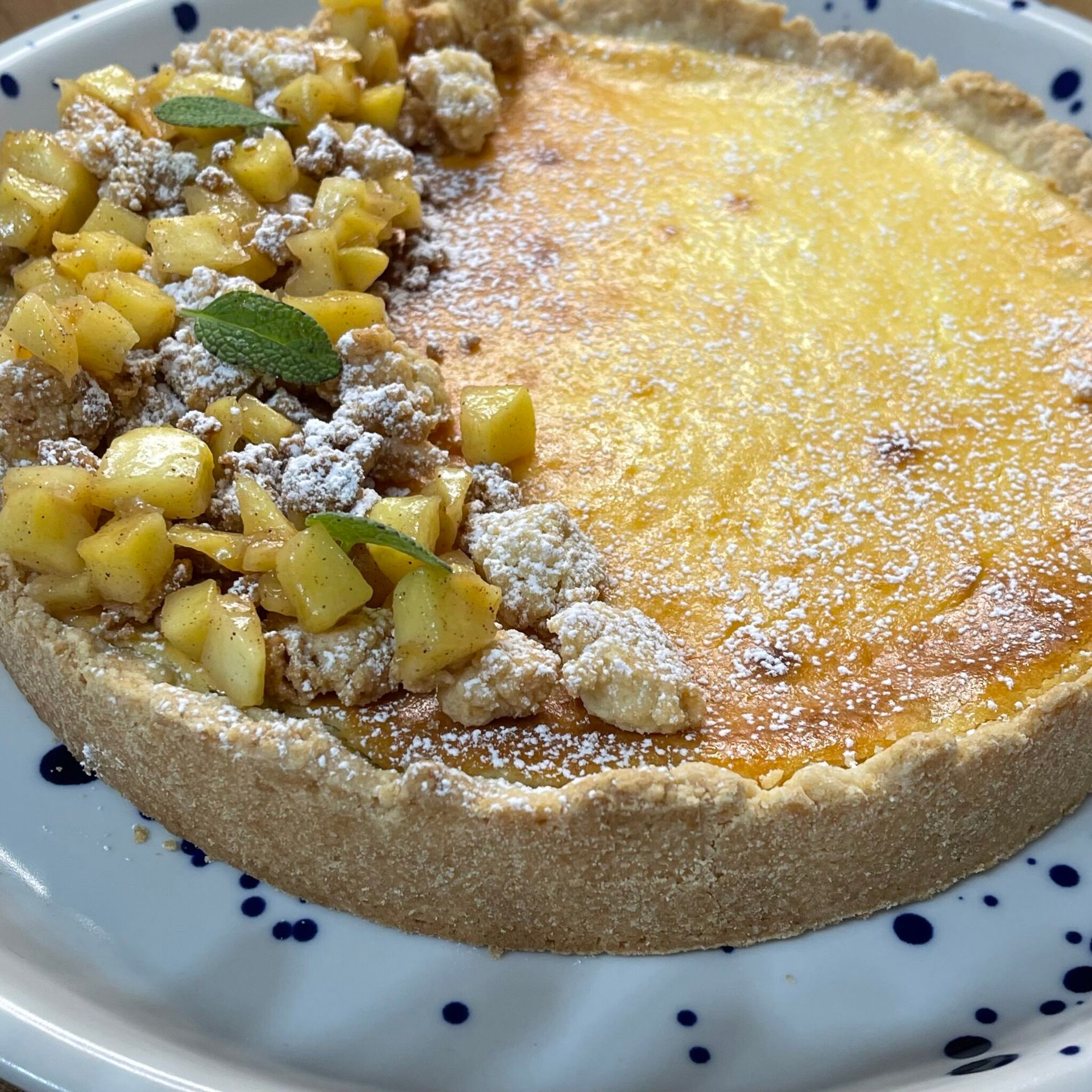 Una torta con mele e zucchero a velo su un piatto bianco