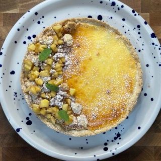 Una torta con zucchero a velo e mele su un piatto bianco