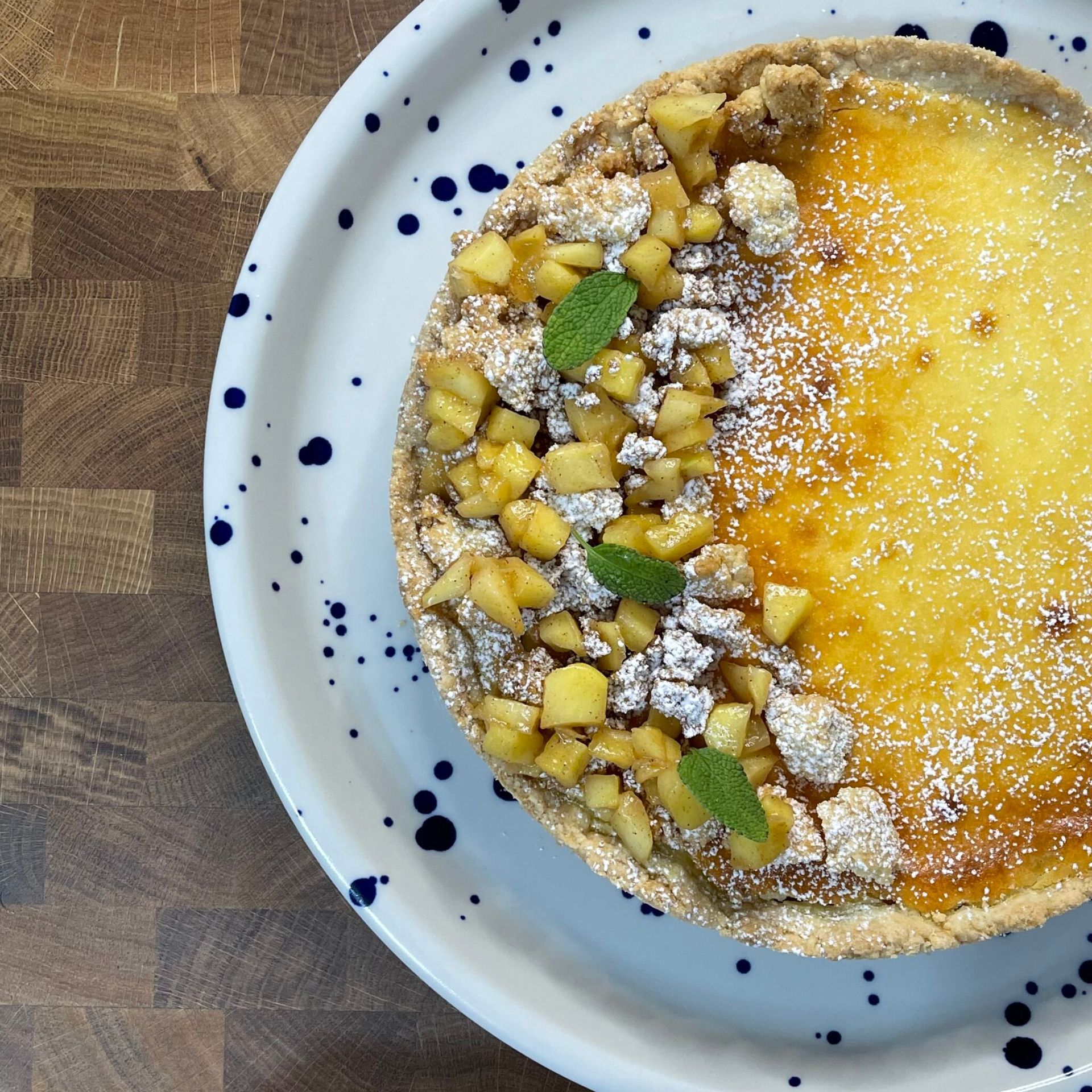Una torta su un piatto con zucchero a velo e foglie di menta