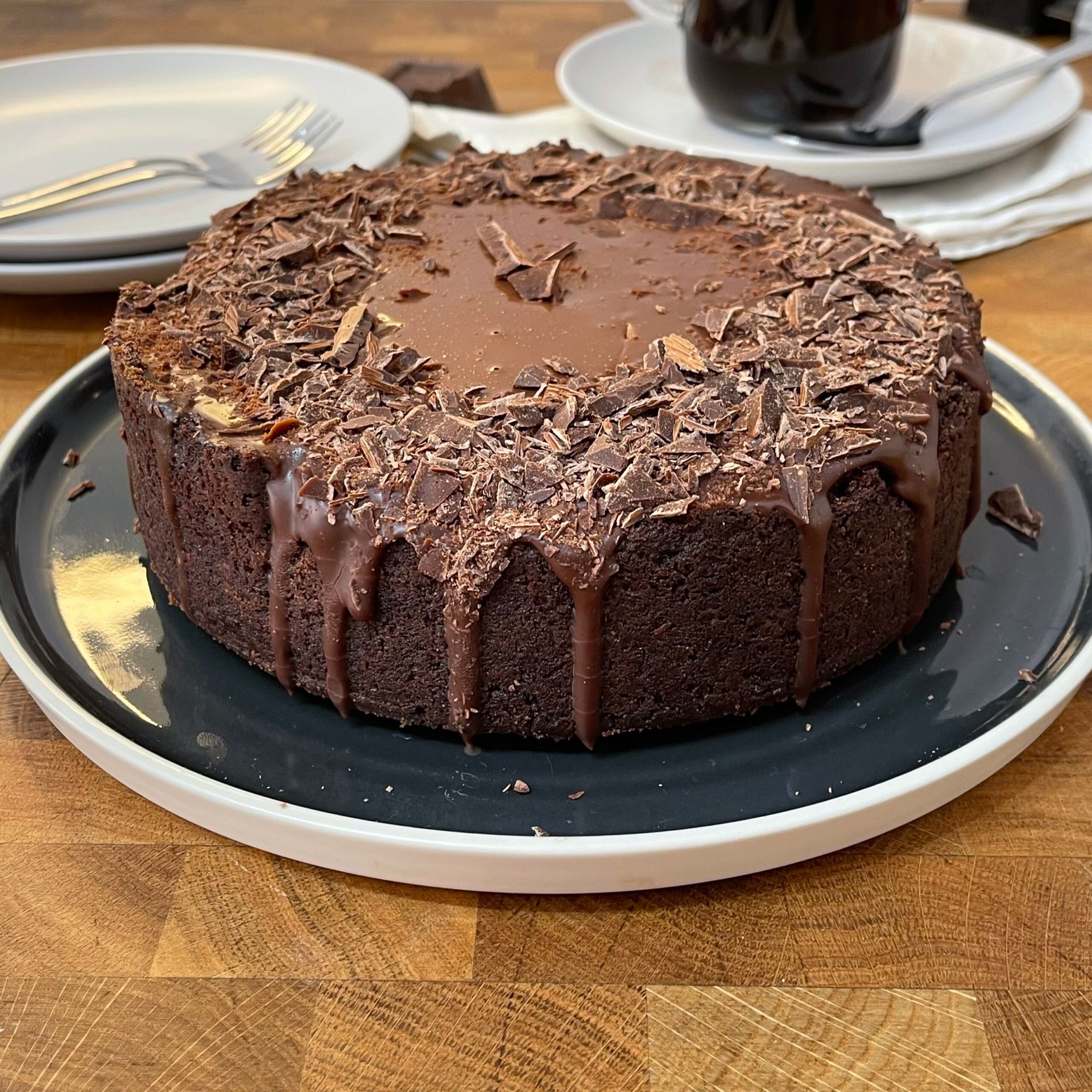 Una torta al cioccolato è appoggiata su un piatto su un tavolo.