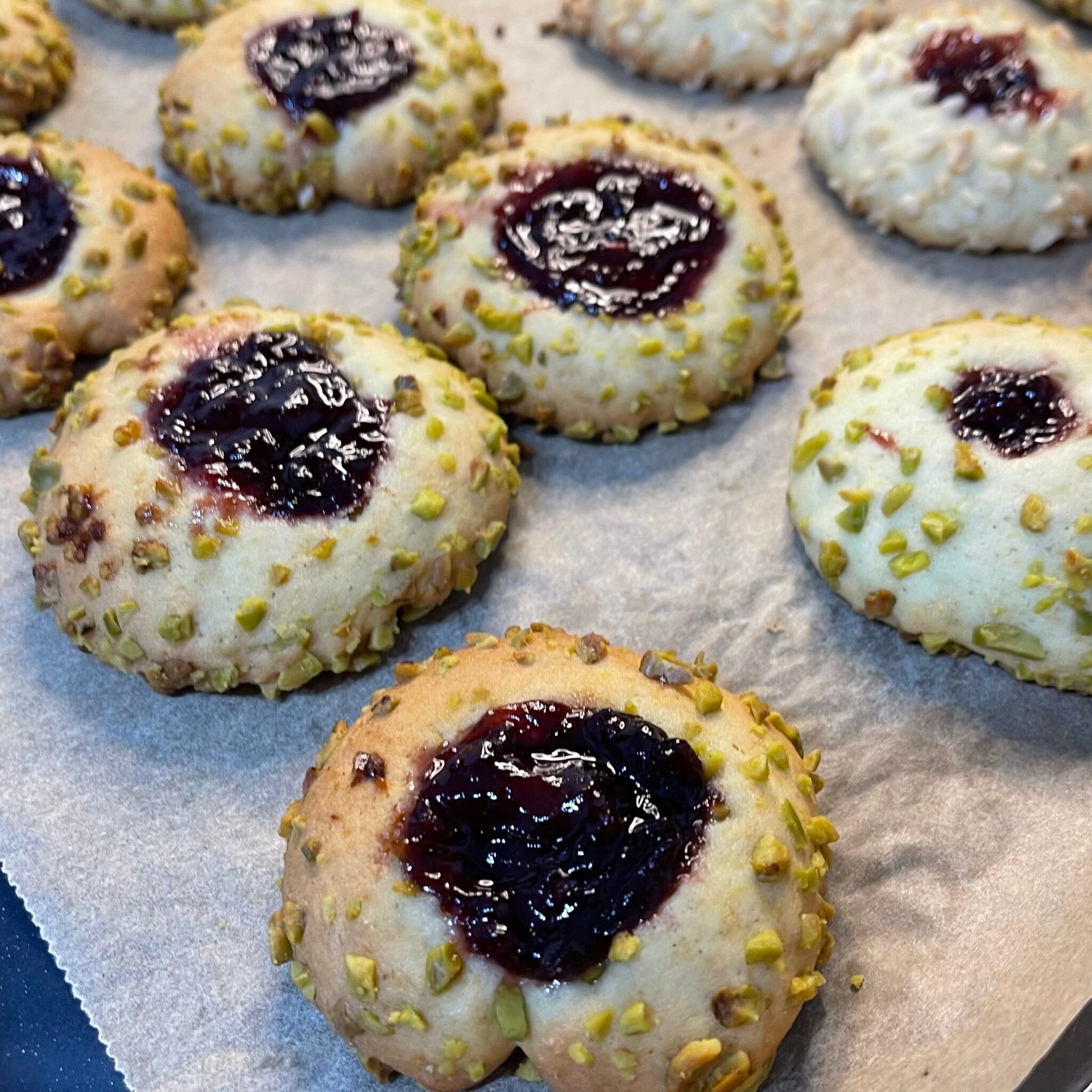Un mucchio di biscotti con gelatina e pistacchi sopra