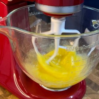 Un mixer KitchenAid rosso pieno di liquido giallo