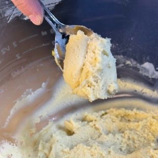 Una persona tiene un cucchiaio sopra una ciotola di purè di patate