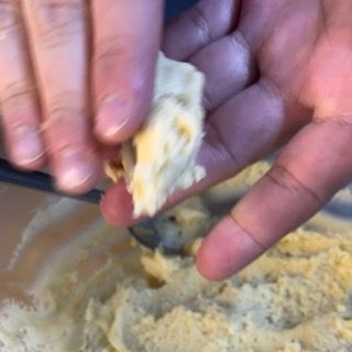 Una persona tiene in mano un pezzo di pasta