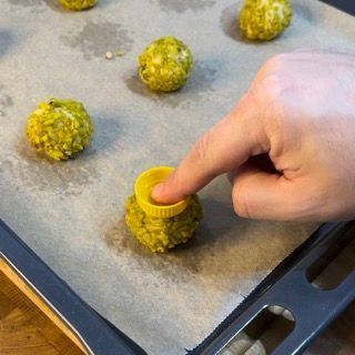 Una persona sta mettendo un coperchio giallo su una palla verde