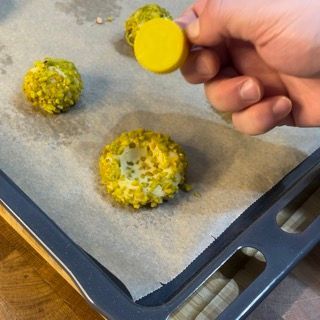 Una persona tiene in mano un piccolo oggetto giallo sopra un vassoio di cibo