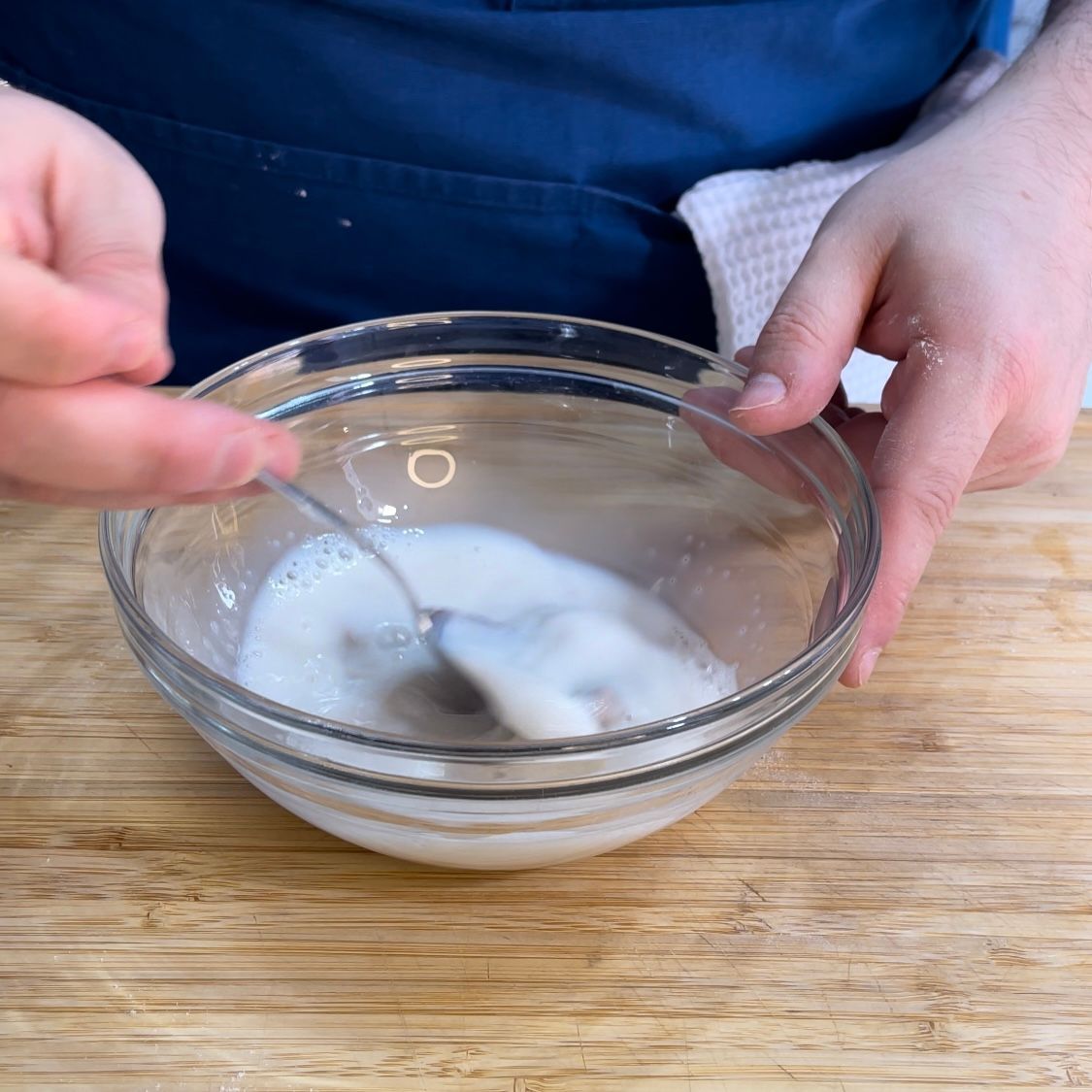 Una persona sta mescolando una ciotola di liquido con un cucchiaio.