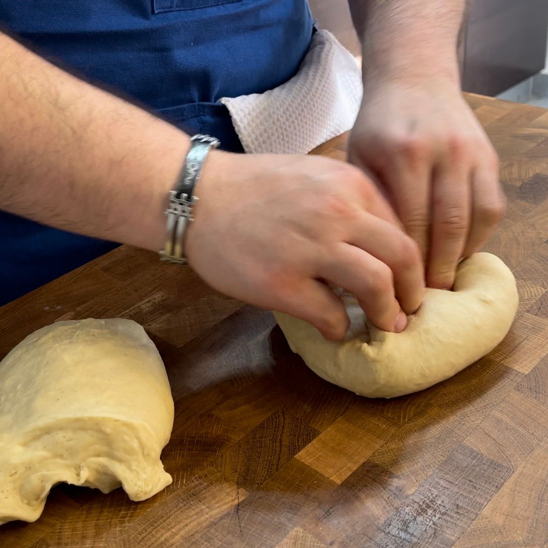 Una persona sta impastando la pasta su un tagliere di legno