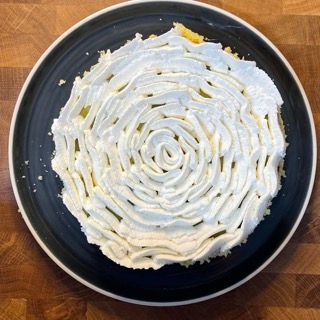 Un piatto nero sormontato da un vortice di panna montata