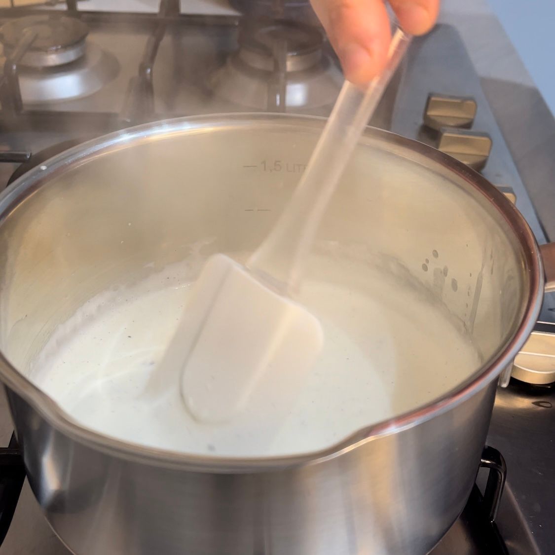 Una persona sta mescolando una pentola di liquido con una spatola