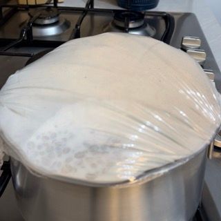 Una pentola è coperta con pellicola di plastica sul fornello