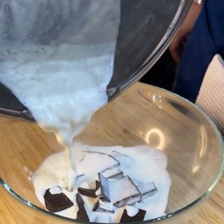 Il latte viene versato in una ciotola di vetro con pezzi di cioccolato